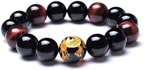 Natural 12 mm tiger eye beads with etched dragon patterns string beside porous black lava rock and dark created crystal.