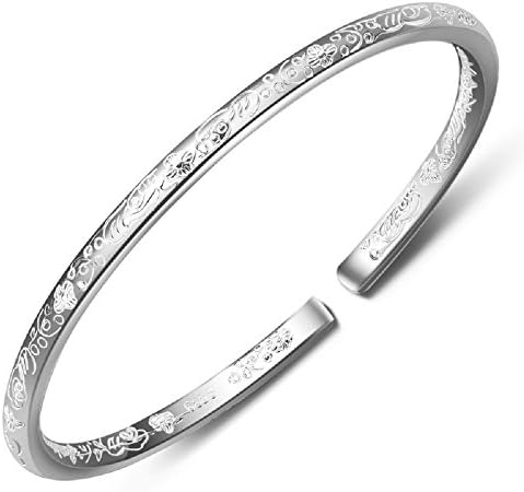 Solid 999 silver cuff with carved flower details along the outer band, shaped with an open gap for easy daily wear.